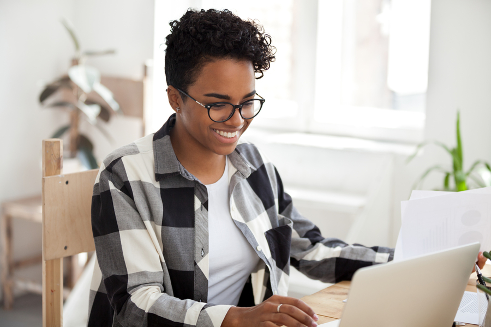 Woman smiling while looking at her laptop computer.